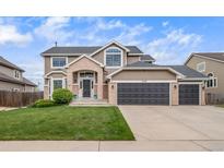 Charming home featuring a three-car garage and a manicured lawn at 9548 La Quinta Dr, Lone Tree, CO 80124