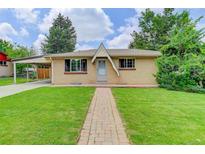 Charming ranch-style home with brick facade, a well-manicured lawn, and inviting walkway at 609 S Quentin St, Aurora, CO 80012