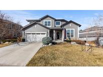 Charming two-story home with a well-manicured lawn and attached two-car garage at 9925 Keenan St, Highlands Ranch, CO 80130