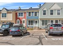 Colorful townhome exteriors with assigned parking spaces on a sunny day at 9240 W Ontario Dr, Littleton, CO 80128