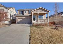 Charming two-story home featuring a covered front porch, landscaped yard, and a two car garage at 24317 E Powers Ave, Aurora, CO 80016