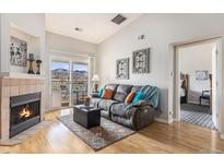 Inviting living room with a fireplace, comfortable seating, and a balcony overlooking a mountain view at 12338 W Dorado Pl # 305, Littleton, CO 80127