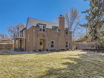 Spacious backyard featuring a well-maintained lawn, brick home exterior, and a cozy outdoor seating area at 2540 Forest St, Denver, CO 80207