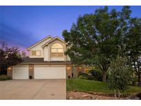 Charming two-story home with a well-maintained lawn, mature trees, and a three-car garage at 7158 Torrey St, Arvada, CO 80007