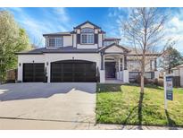 Elegant two-story home boasts a three-car garage and a beautifully landscaped front yard at 6424 S Routt St, Littleton, CO 80127