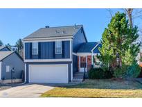 Charming two-story home features a two-car garage, blue siding, and professionally landscaped front yard at 11574 W 106Th Way, Broomfield, CO 80021