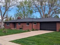 Charming red brick home with a well-manicured lawn and attached two car garage at 3400 Moore St, Wheat Ridge, CO 80033