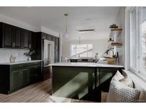 Modern kitchen boasts sleek dark cabinets, stainless steel appliances, and a stylish island at 3400 Moore St, Wheat Ridge, CO 80033