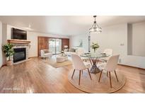 Bright living room featuring a stone fireplace, hardwood floors, and glass dining table at 23678 Pondview Pl # D, Golden, CO 80401