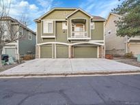 Green townhome exterior with three-car garage and balcony at 1358 Carlyle Park Cir, Highlands Ranch, CO 80129