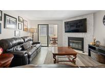 Inviting living room with a fireplace, large leather couch, and glass sliding doors to the outdoor seating area at 534 E 7Th Ave # 206, Denver, CO 80203