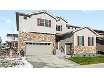 Two-story house with stone accents and a two-car garage at 6307 E 141St Ln, Thornton, CO 80602