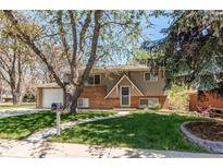 Charming two-story home featuring a well-manicured lawn and mature trees in a quiet neighborhood at 5898 Parfet Ct, Arvada, CO 80004