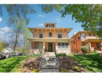 Charming brick home with a welcoming front porch and landscaped front yard on a sunny day at 1176 Gaylord St # 101, Denver, CO 80206
