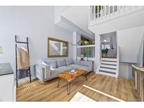 Cozy living room featuring a comfortable sectional couch, wood floors, and decorative accents at 1885 S Quebec Way # J106, Denver, CO 80231
