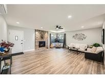 Bright living room features a stone fireplace, and hardwood floors at 21 Douglas N Dr, Broomfield, CO 80020