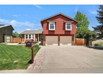 Charming red split-level home with an attached two-car garage and well-maintained front lawn at 8065 W Fremont Dr, Littleton, CO 80128