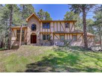 Charming two-story Tudor home with brick and stucco accents and a manicured lawn at 70 Long Bow Cir, Monument, CO 80132