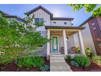 Charming two-story home featuring a covered front porch with rocking chairs and beautifully landscaped front yard at 6632 Osage St, Denver, CO 80221