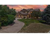 Charming two-story home featuring a three-car garage, lush lawn, and mature trees at 14652 Kalamath Ct, Westminster, CO 80023