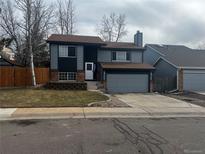 Charming two-story home with gray siding, brick accents, attached garage, and freshly landscaped front yard at 20328 E Powers Ln, Aurora, CO 80015