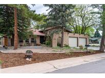 Charming single-story home boasting a brick facade, tiled roof, and a welcoming two-car garage at 8793 E Monmouth Pl, Denver, CO 80237