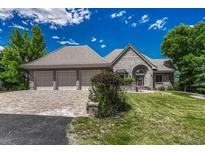 Charming single Gathering home with brick exterior, manicured lawn, and three-car garage at 5 Catamount Ln, Littleton, CO 80127