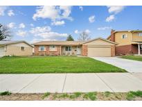Charming ranch-style home boasts a well-manicured lawn, inviting curb appeal, and an attached two-car garage at 490 Potomac Way, Aurora, CO 80012