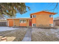 Charming orange brick home featuring a red front door and well-maintained yard at 3164 Scranton St, Aurora, CO 80011