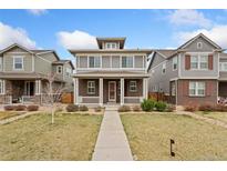 Charming two-story home with brick accents, covered porch, and landscaped front yard at 631 E Hinsdale Ave, Littleton, CO 80122