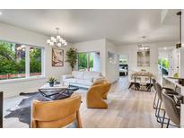 Bright living room with modern chandelier, stylish furnishings, and view to the outdoors at 1308 Snowberry Ln # 303, Louisville, CO 80027