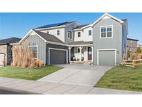 Two-story farmhouse with gray siding, attached garage, and landscaped lawn at 4911 Colorado River Dr, Firestone, CO 80504