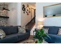 Cozy living room featuring stylish decor, comfortable seating, and a staircase leading to the upper level at 19044 E 16Th Ave, Aurora, CO 80011