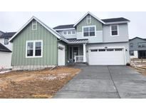 Charming two-story home featuring a two-car garage, welcoming porch, and stylish green and gray color scheme at 39877 Floyd St, Elizabeth, CO 80107