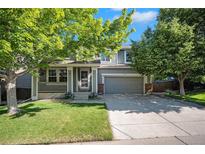 Charming two-story home with a well-maintained front yard and inviting porch, shaded by mature trees at 735 Poppy Pl, Highlands Ranch, CO 80129
