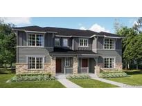 Charming gray two-story home with stone accents, well-manicured lawn, and covered entryway at 15232 Detroit St, Thornton, CO 80602