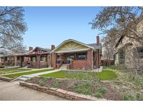 Charming brick home with a well-manicured lawn and inviting front porch at 586 S Corona St, Denver, CO 80209