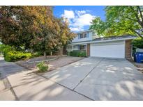 Charming two-story home featuring a well-manicured lawn, mature trees, and a spacious driveway at 4474 S Vrain St, Denver, CO 80236