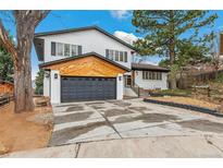 Charming two-story home with a modern garage, landscaped yard and white exterior, and large driveway at 13232 W Jewell Cir, Lakewood, CO 80228