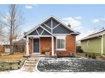 Charming red brick home featuring a minimalist landscaped yard, covered entry and inviting front bench at 4030 W 49Th Ave, Denver, CO 80212
