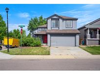 Charming two-story home boasts a well-manicured lawn, gray siding, and an attached two-car garage at 8791 Starwood Ln, Parker, CO 80134