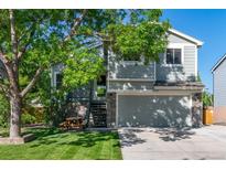 Charming two-story home featuring a lush front lawn, a two-car garage, and stone accents at 11777 Elizabeth Cir, Thornton, CO 80233