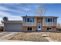 Charming two-story home with brick accents, blue shutters and attached garage, offering classic curb appeal at 14798 E Temple Dr, Aurora, CO 80015