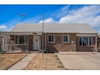 Charming brick single-story home with manicured lawn and cozy covered porch in a residential neighborhood at 865 S Dale Ct, Denver, CO 80219