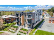 Modern townhome with gray siding, stone accents, and balconies in a landscaped community with mountain views at 1385 N King St, Denver, CO 80204