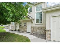 Charming townhome with stone accents, lush landscaping, and multiple windows at 2253 Coronado Pkyn # D, Denver, CO 80229