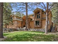 Stunning two-story home featuring stone accents and a well-manicured lawn, perfect for mountain living at 20050 Lost Arrowhead Dr, Monument, CO 80132
