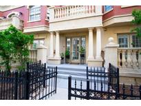 Elegant building entrance featuring stately columns, a wrought iron fence, and manicured landscaping at 1950 N Logan St # 102, Denver, CO 80203