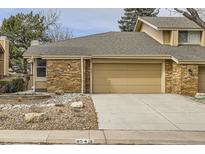 Two-story home boasts a tan brick facade, two-car garage, and well-maintained landscaping at 8543 Redstone St, Highlands Ranch, CO 80126
