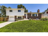 Inviting two-story home with a well-manicured lawn, a driveway, and a combination of brick and siding at 6348 S Independence St, Littleton, CO 80123